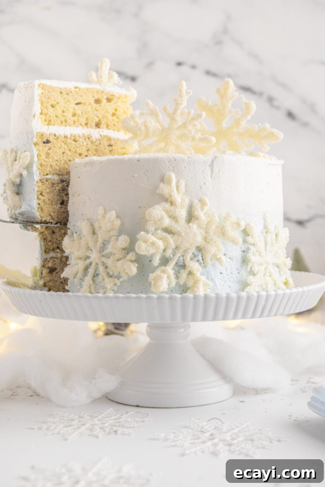 Crystalline Dream Cake 3 Removing a slice of Snowflake Cake revealing the layers of white cake and ombre blue and white buttercream.