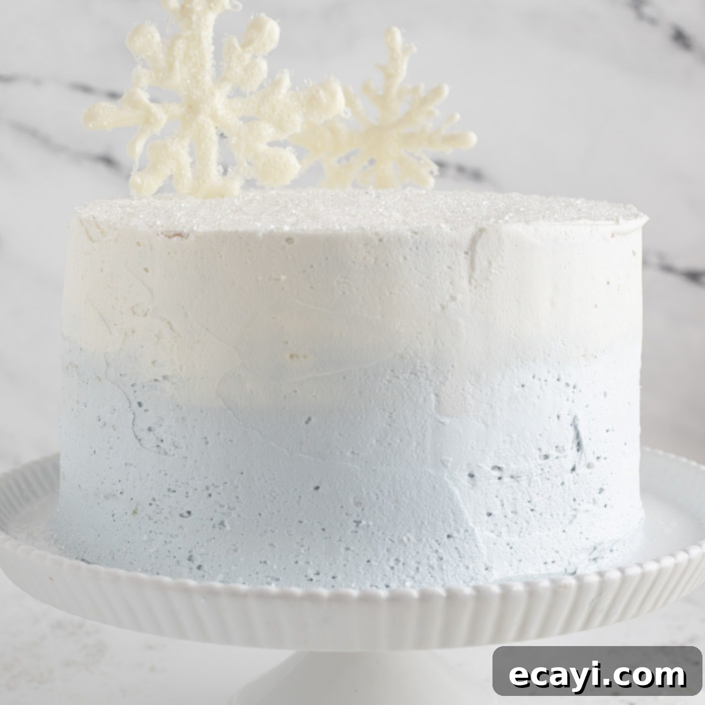 Crystalline Dream Cake 23 White chocolate snowflakes added to a tiered cake, standing upright on top.