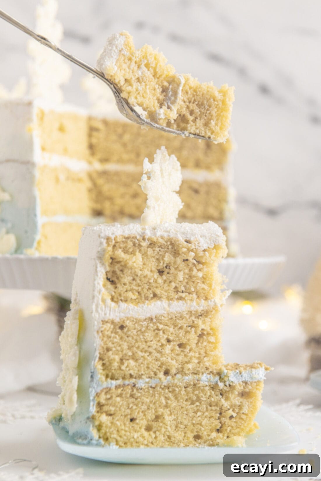 Crystalline Dream Cake 24 A perfectly cut slice of Snowflake Cake showing the multiple layers, ombre frosting, and delicate snowflake details.