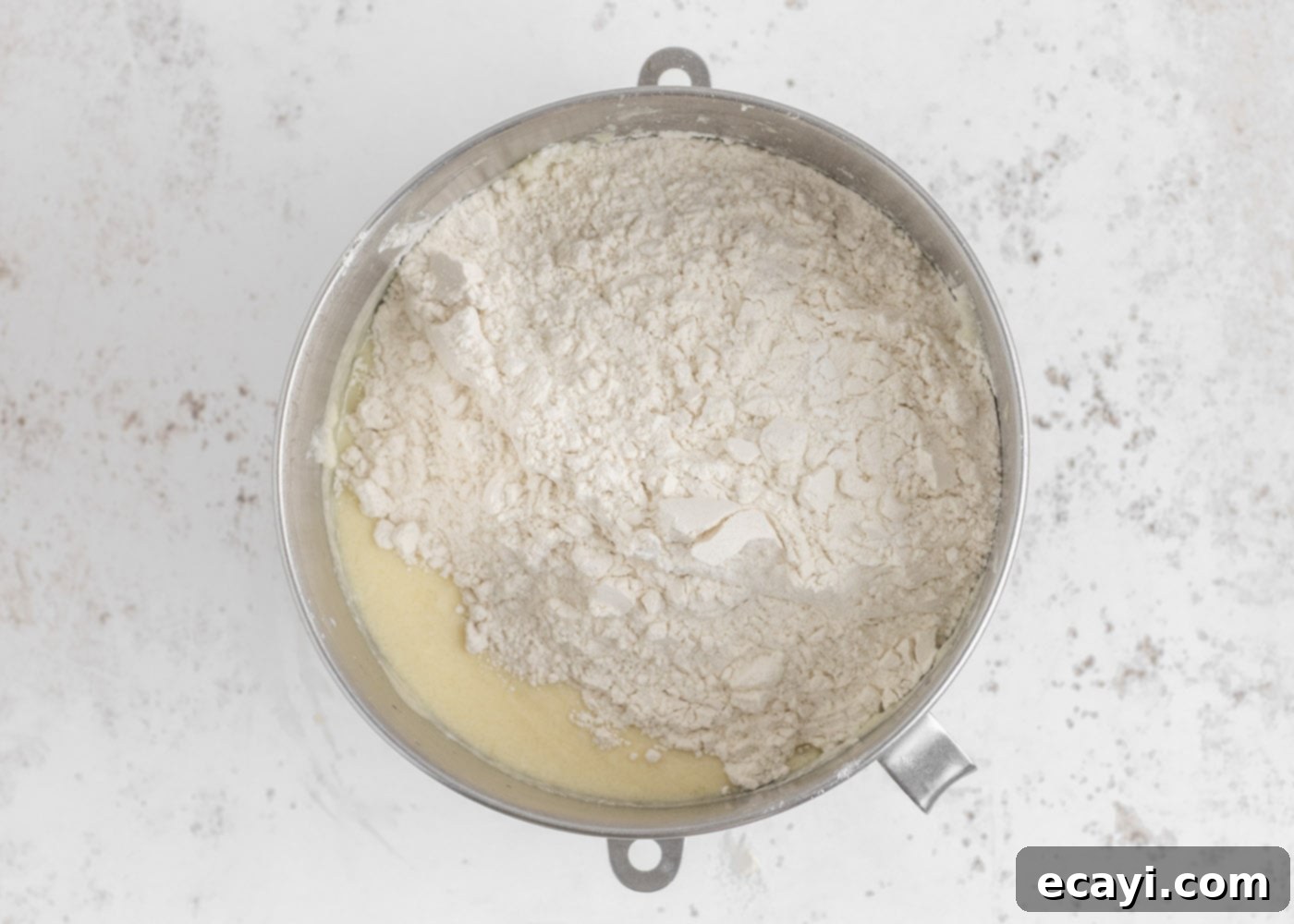 Crystalline Dream Cake 8 Flour mixture added to wet cake batter ingredients, ready to be gently combined.