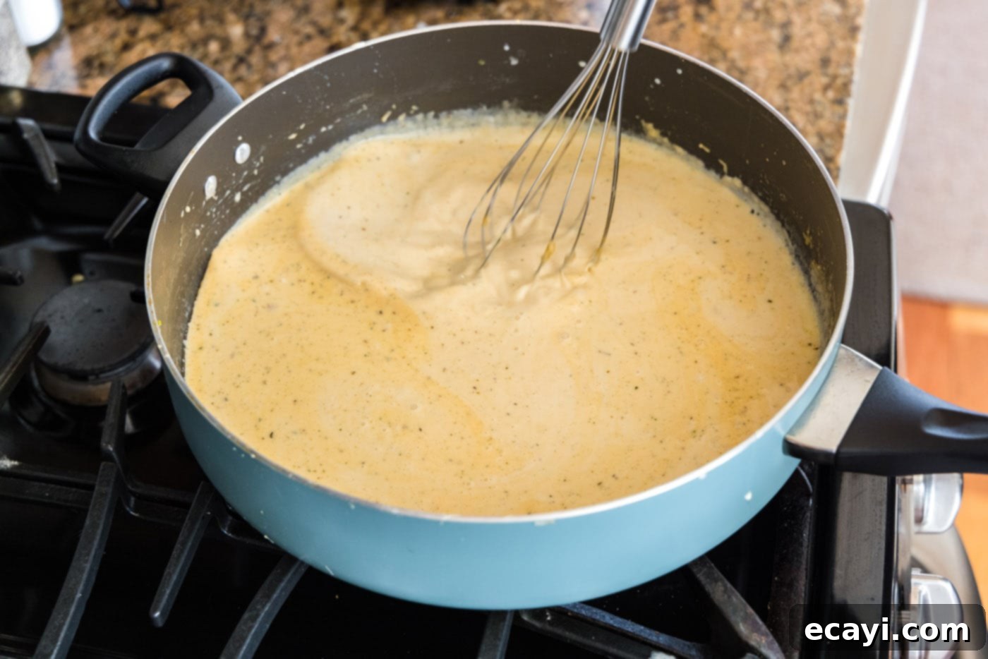 Ocean's Bounty Lasagna 14 Whisking the cream sauce in a saucepan until it is smooth and slightly thickened.