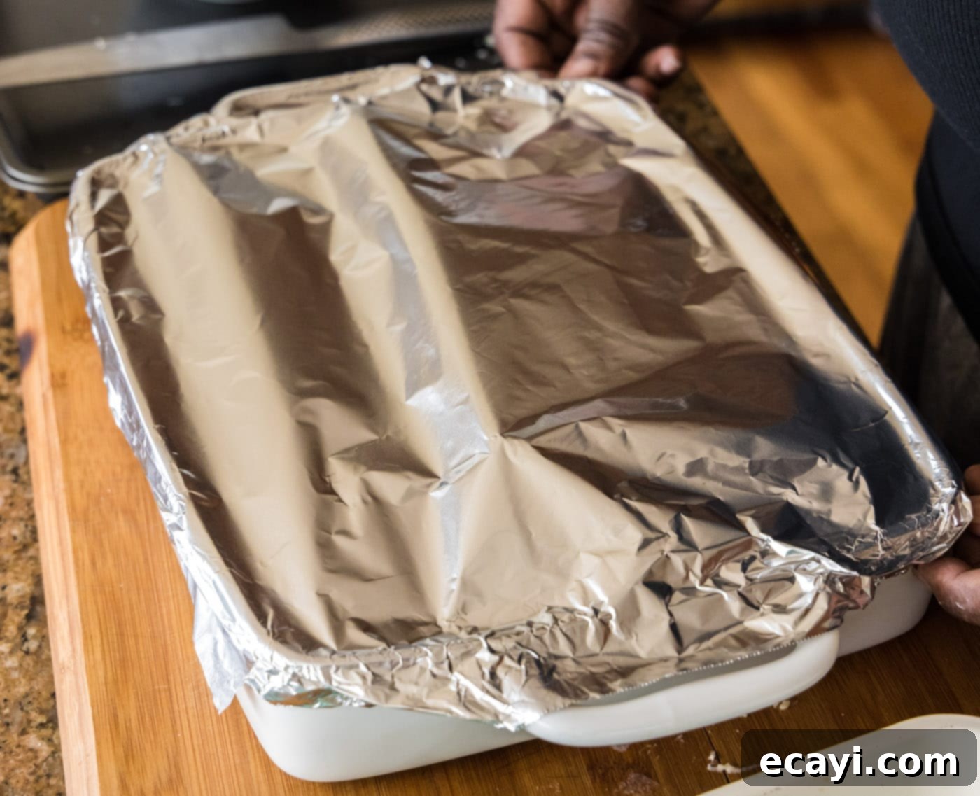 Ocean's Bounty Lasagna 23 Seafood lasagna baking in the oven, covered with aluminum foil.