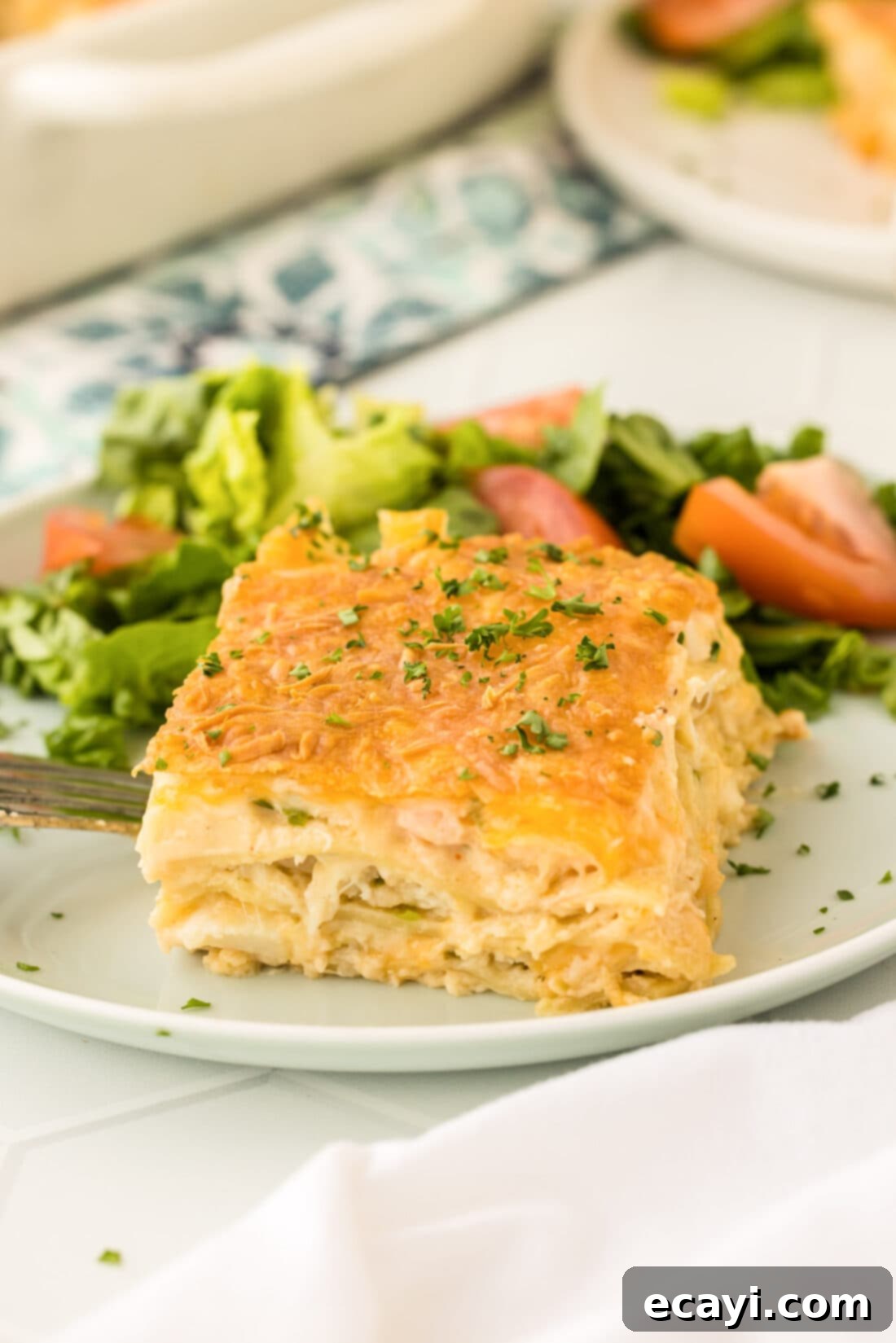 Ocean's Bounty Lasagna 24 A large slice of creamy seafood lasagna served on a plate, showing the distinct layers and golden-brown cheese.