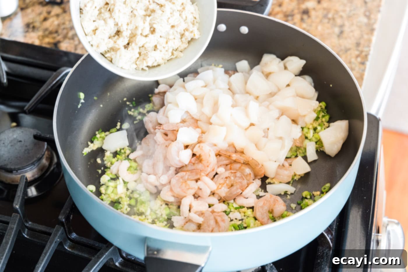 Ocean's Bounty Lasagna 6 Adding various seafood, green onions, and garlic to a large skillet.
