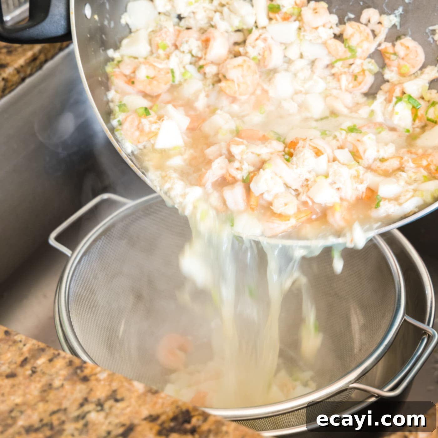 Ocean's Bounty Lasagna 8 Draining cooked seafood mixture into a colander to separate solids from liquid.