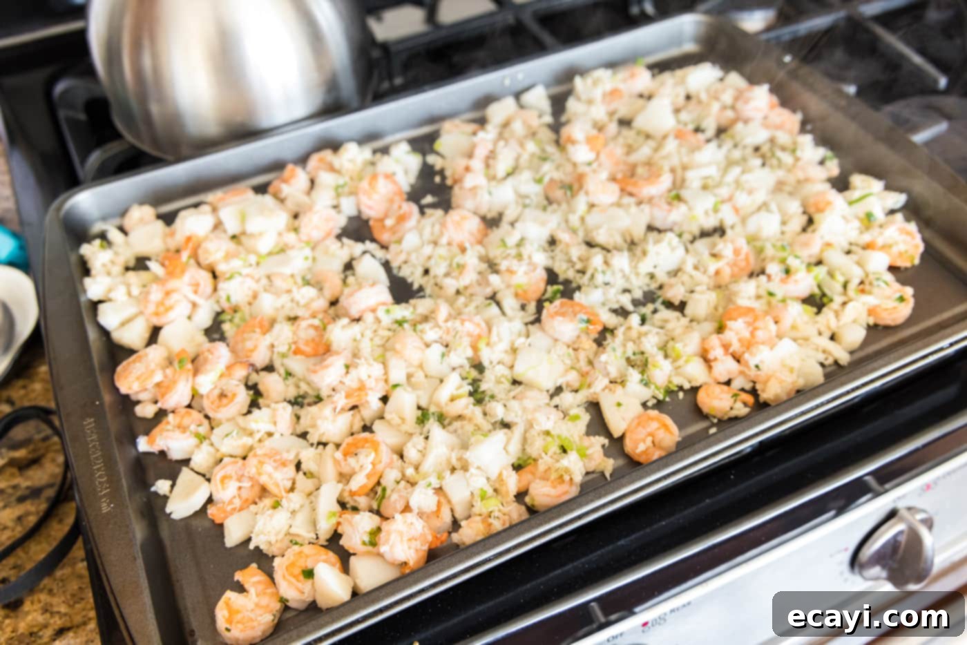 Ocean's Bounty Lasagna 9 Cooked crab meat, scallops, and shrimp spread on a baking tray to cool down.