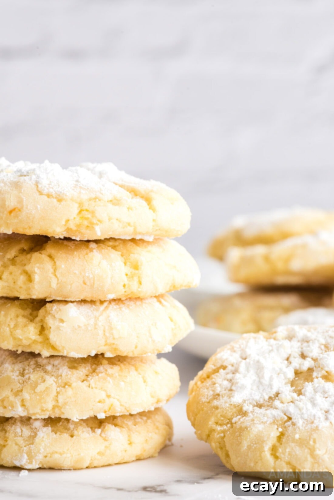 Orange Crinkle Cookies: A delicious, chewy treat made with real orange juice and zest, then coated in powdered sugar and baked to perfection. Freshly baked orange crinkle cookies cooling on a wire rack, showing off their perfect powdered sugar coating.