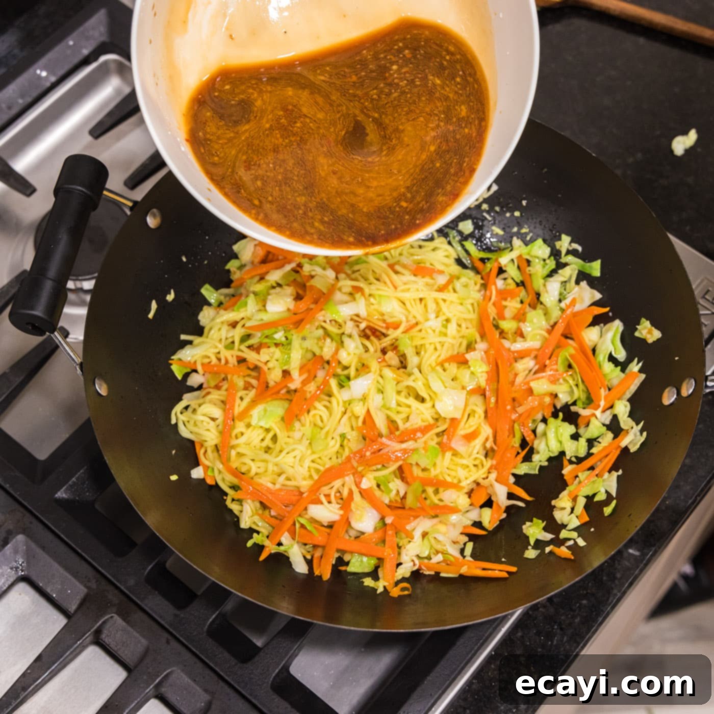 Chow Mein 10 pouring chow mein sauce into wok with vegetables