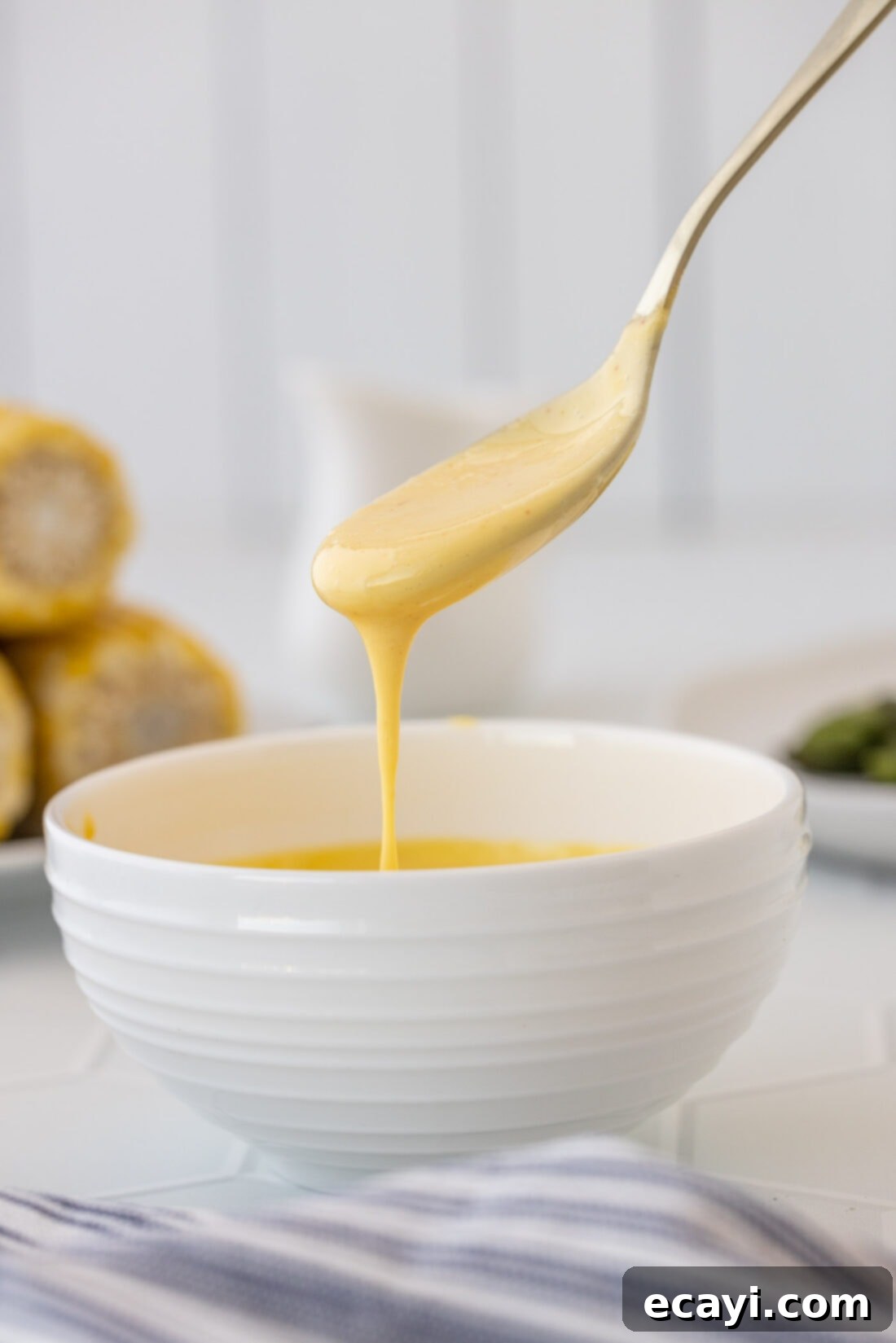 Classic Hollandaise Sauce 2 spoon drizzling Hollandaise Sauce