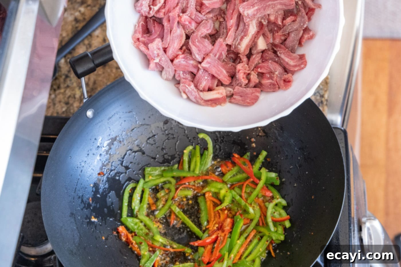 Fiery Szechuan Beef 12 Adding flank steak to the wok with stir-fried vegetables