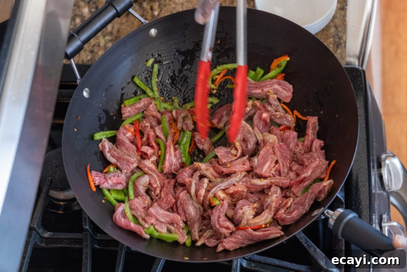 Fiery Szechuan Beef 13 Mixing beef and vegetables together in a wok during stir-frying