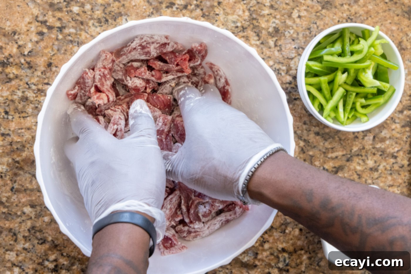 Fiery Szechuan Beef 6 Hands mixing sliced steak with cornstarch, ensuring even coating