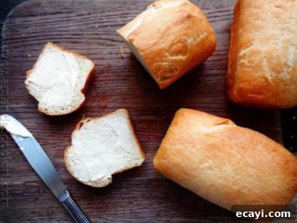 Amish White Bread Mini Loaves - AmandasCookin.com A photo of sliced Amish white bread mini loaves on a wooden cutting board.