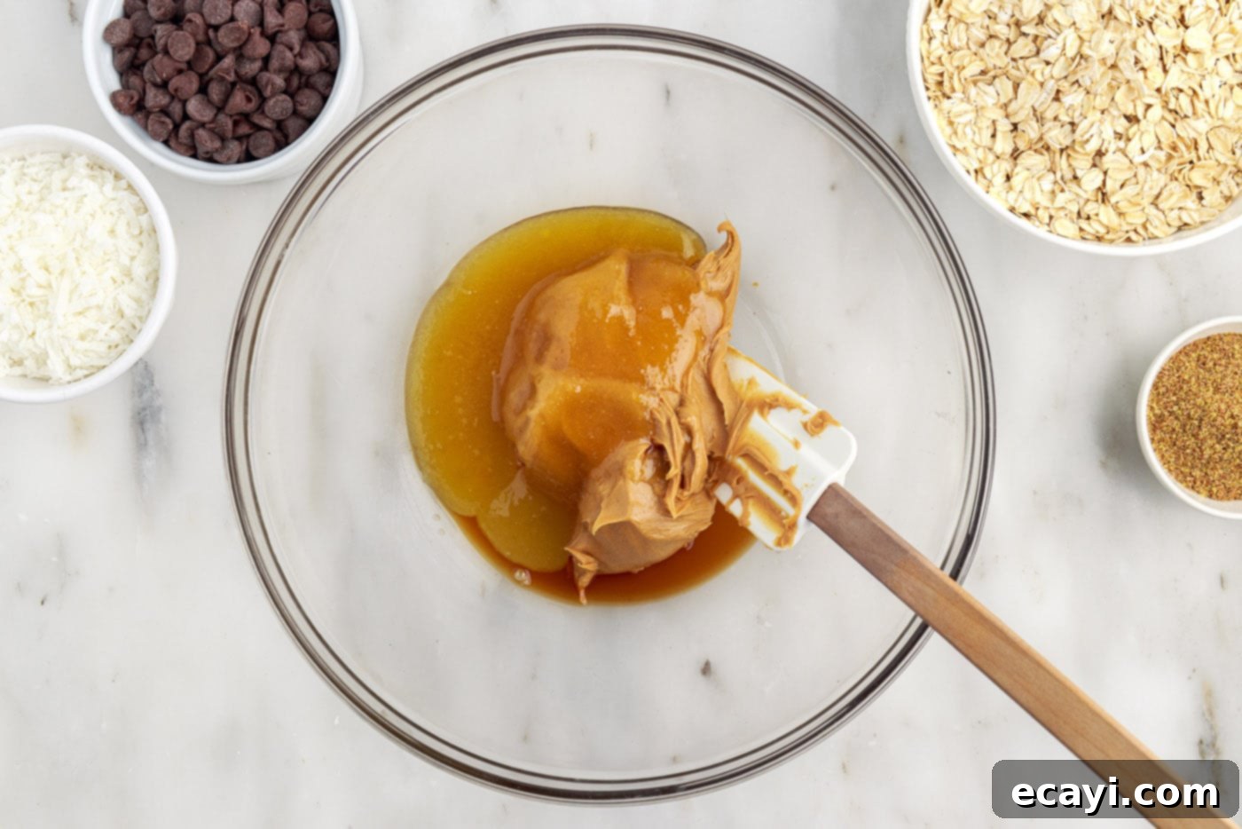 Effortless Energy Bites 5 mixing peanut butter, honey, and vanilla in a bowl with a rubber spatula