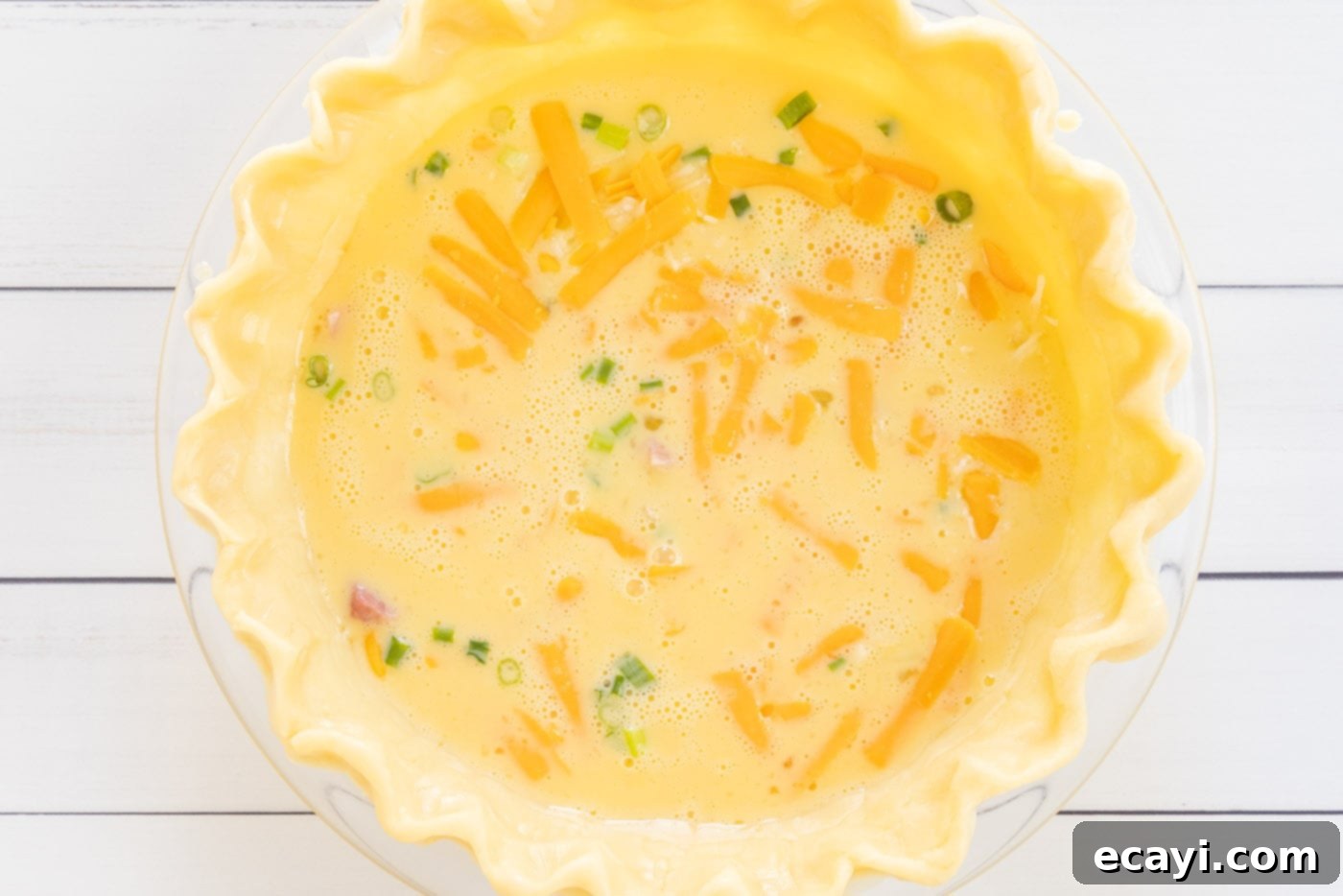 Savory Egg Custard Pie 8 A deep-dish pie shell filled with the first half of ham, green onions, cheeses, and egg mixture for the quiche.