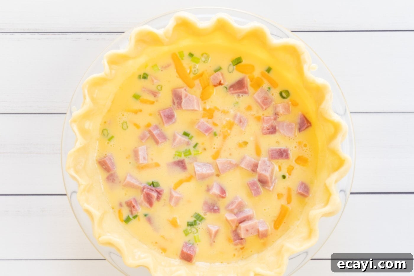 Savory Egg Custard Pie 9 The second layer of cubed ham being added to the quiche filling in the pie shell.
