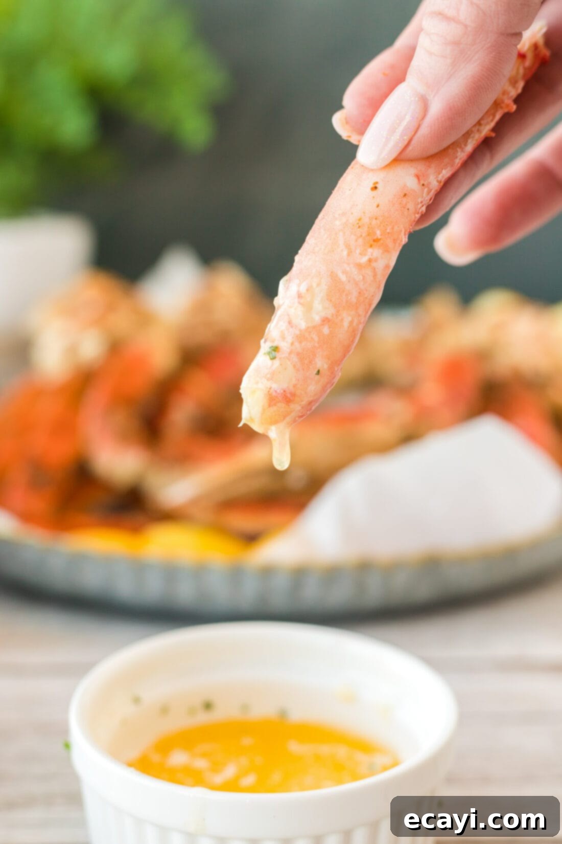 Arctic Crab Delights 10 Close-up of a piece of snow crab leg being dipped into melted butter