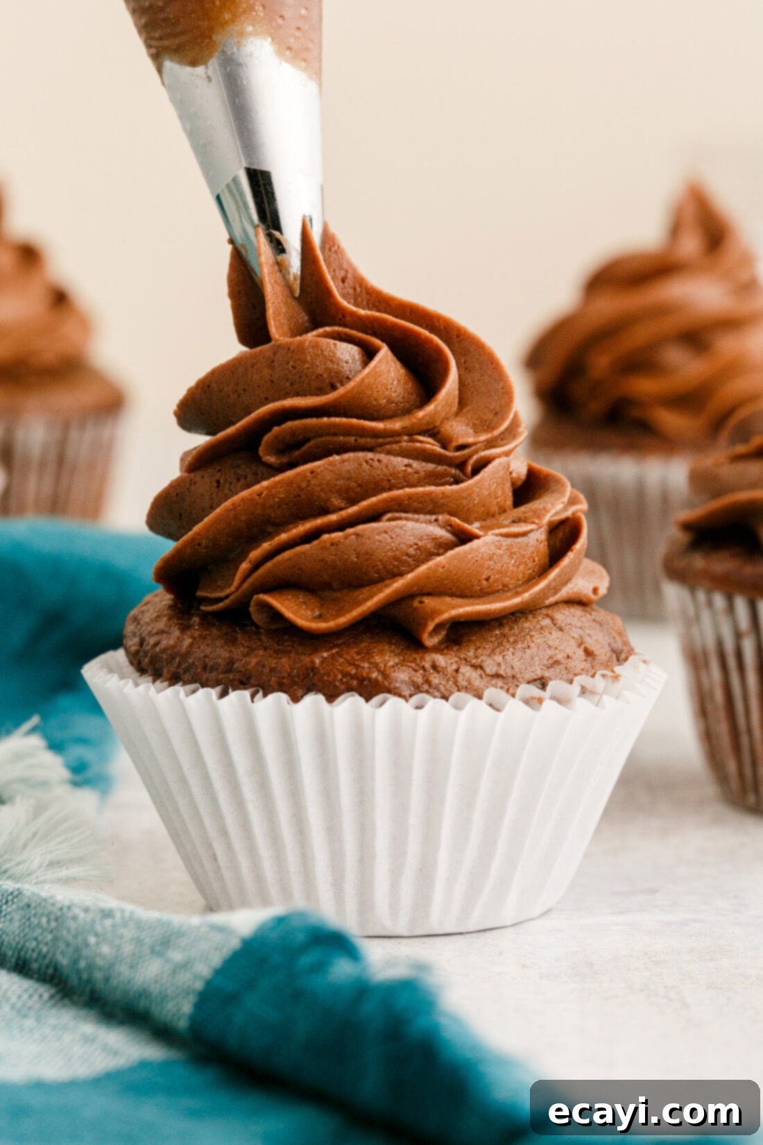 Velvety Chocolate Dream Frosting 2 piping Chocolate Buttercream Frosting onto a cupcake