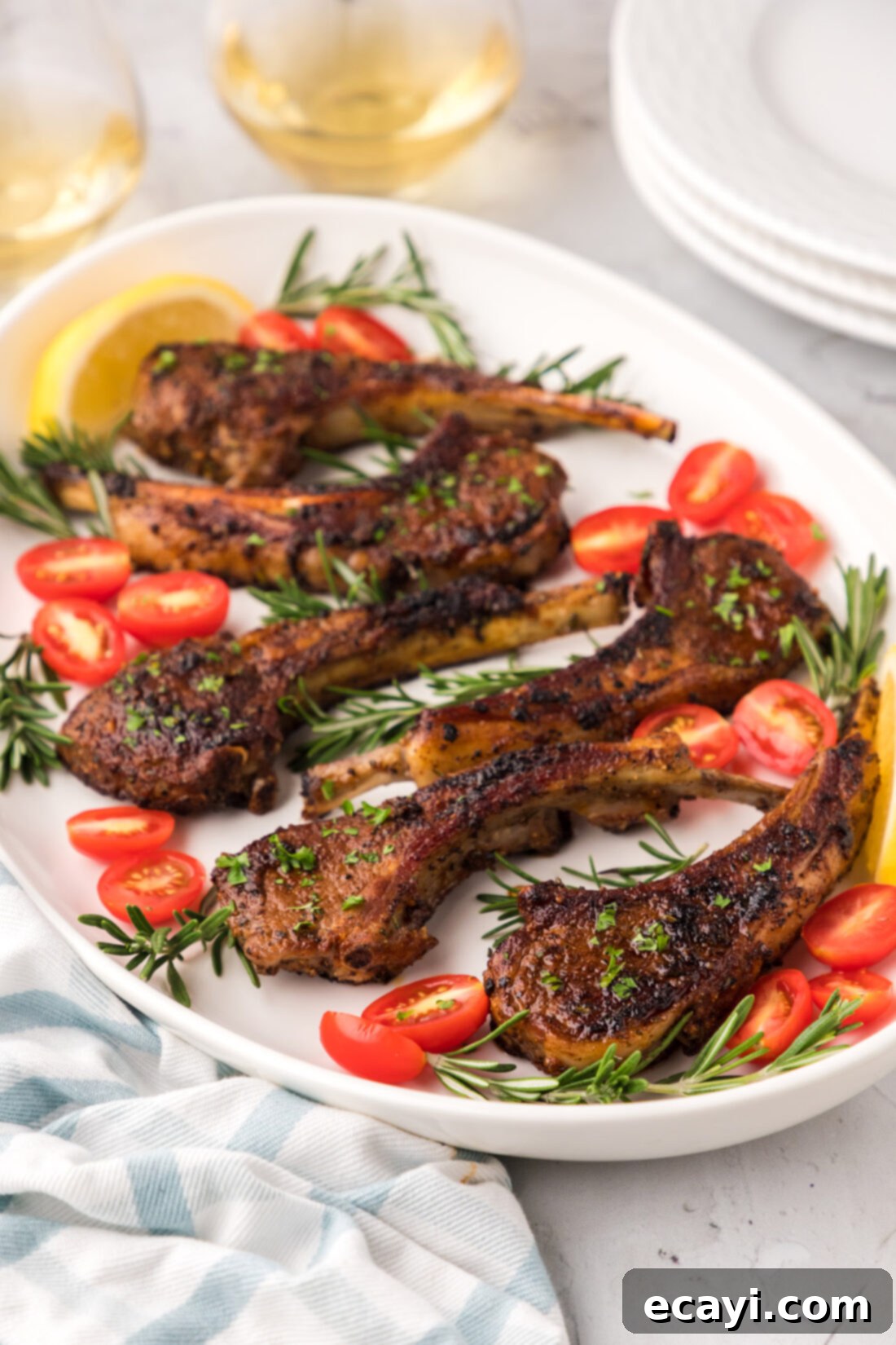 Tender Oven-Baked Lamb Chops 2 Two golden-brown baked lamb chops served on an elegant platter, garnished with fresh rosemary.