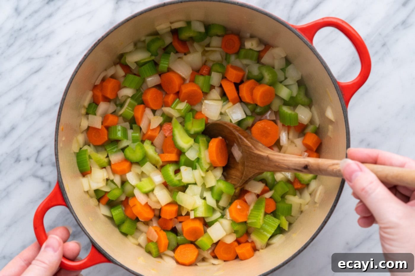 Soul-Warming Lentil Soup 6 Sautéing chopped onion, celery, and carrots with olive oil in a large pot, creating the aromatic base for lentil soup.