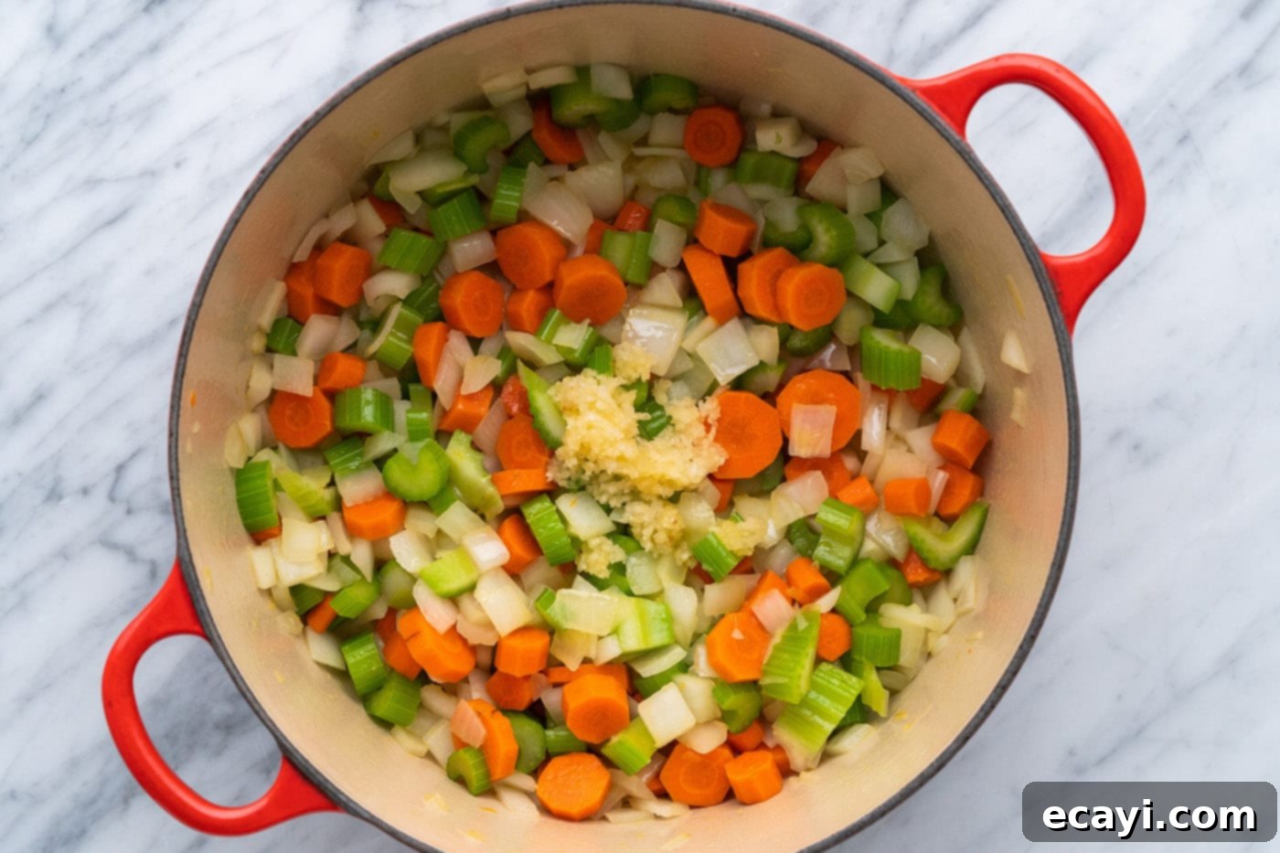Soul-Warming Lentil Soup 7 Adding minced garlic to the sautéed onion, celery, and carrots in a pot, infusing rich aroma.
