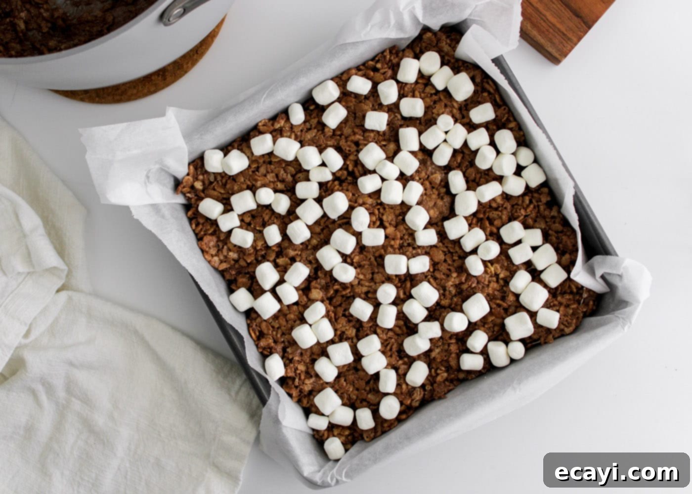 Cozy Cocoa Krispie Squares 11 hot cocoa rice krispie treats in a pan, topped with extra mini marshmallows, cooling
