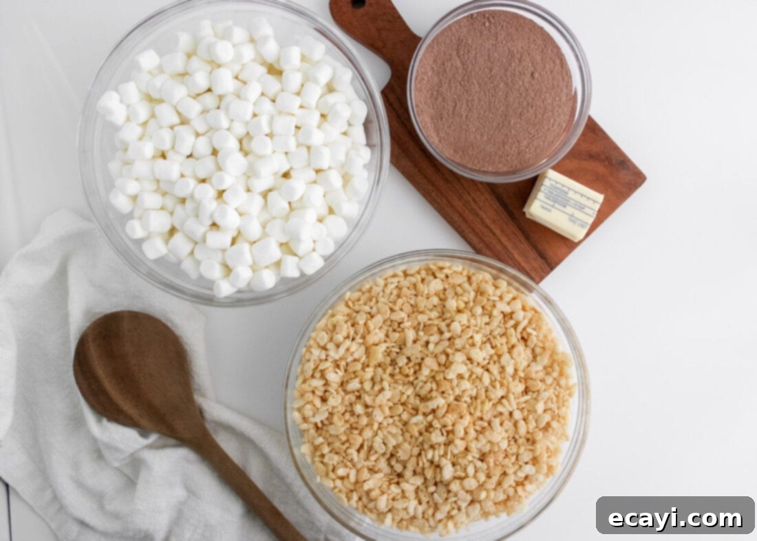 Cozy Cocoa Krispie Squares 4 ingredients for Hot Cocoa Rice Krispie Treats laid out: butter, mini marshmallows, hot chocolate mix, and rice krispies cereal