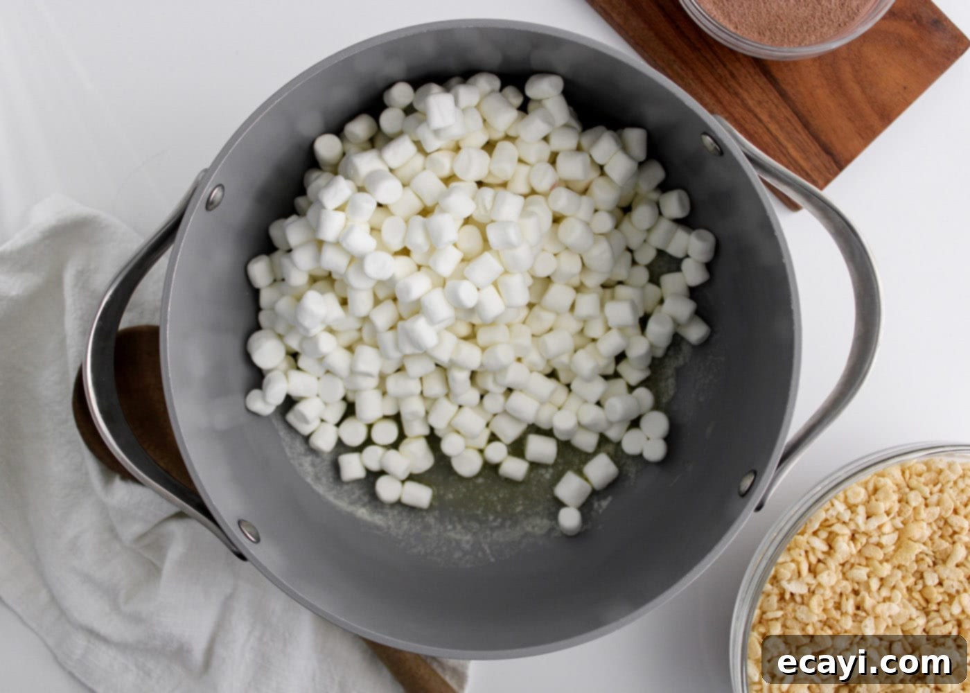 Cozy Cocoa Krispie Squares 5 marshmallows and melted butter in a saucepan, beginning to combine into a gooey mixture