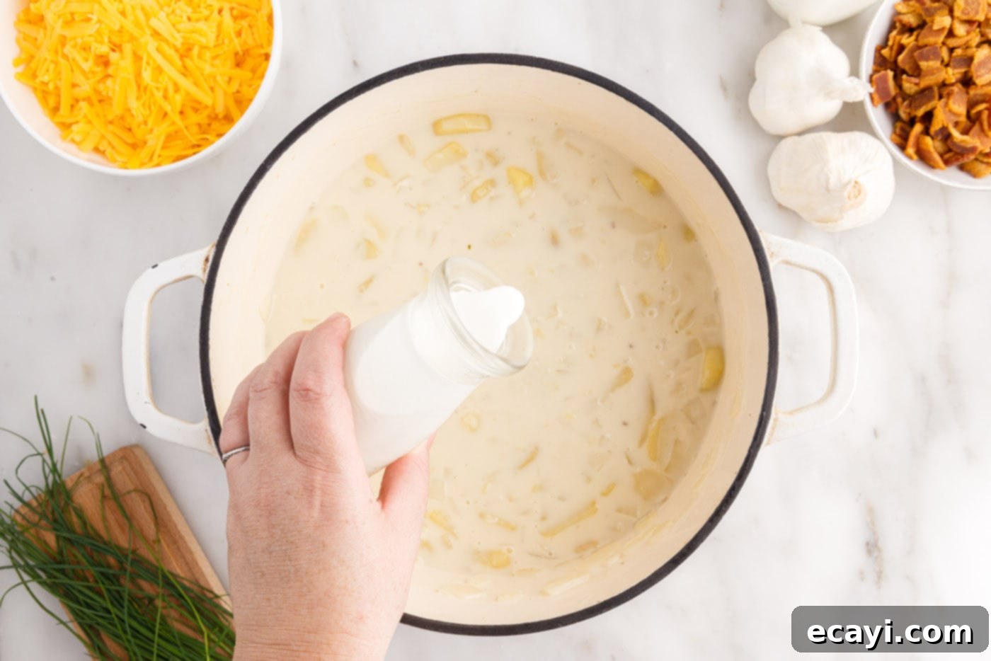Loaded Baked Potato Soup 11 Pouring rich heavy whipping cream into the simmering baked potato soup to enhance its creaminess