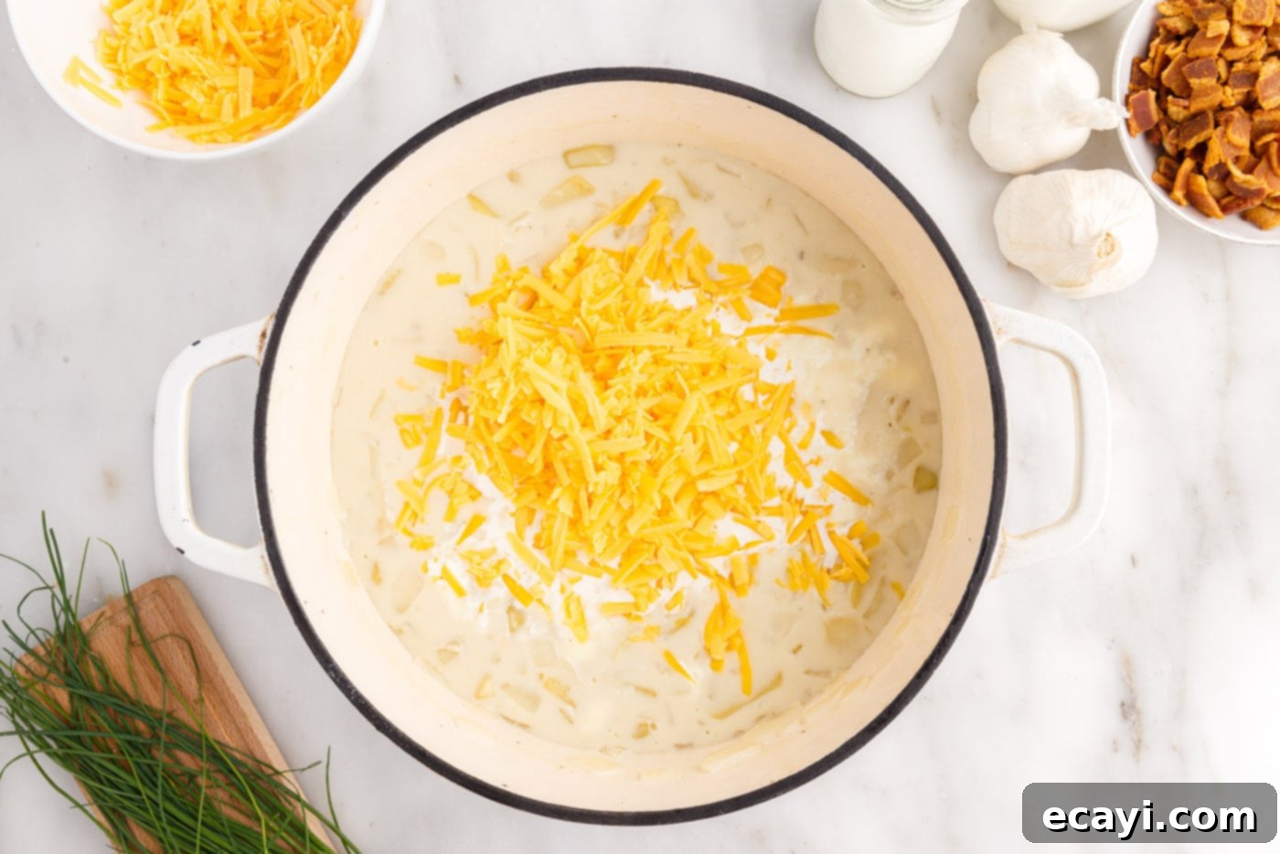 Loaded Baked Potato Soup 12 Adding a generous amount of freshly shredded cheddar cheese to the creamy baked potato soup, allowing it to melt into a smooth texture