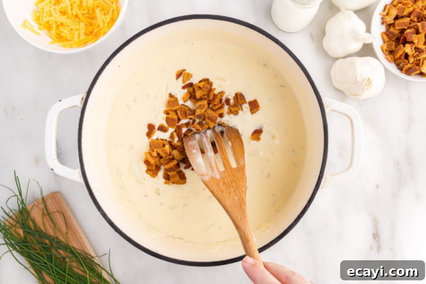 Loaded Baked Potato Soup 13 Stirring crispy, crumbled bacon pieces into a pot of rich, creamy baked potato soup for added flavor and texture