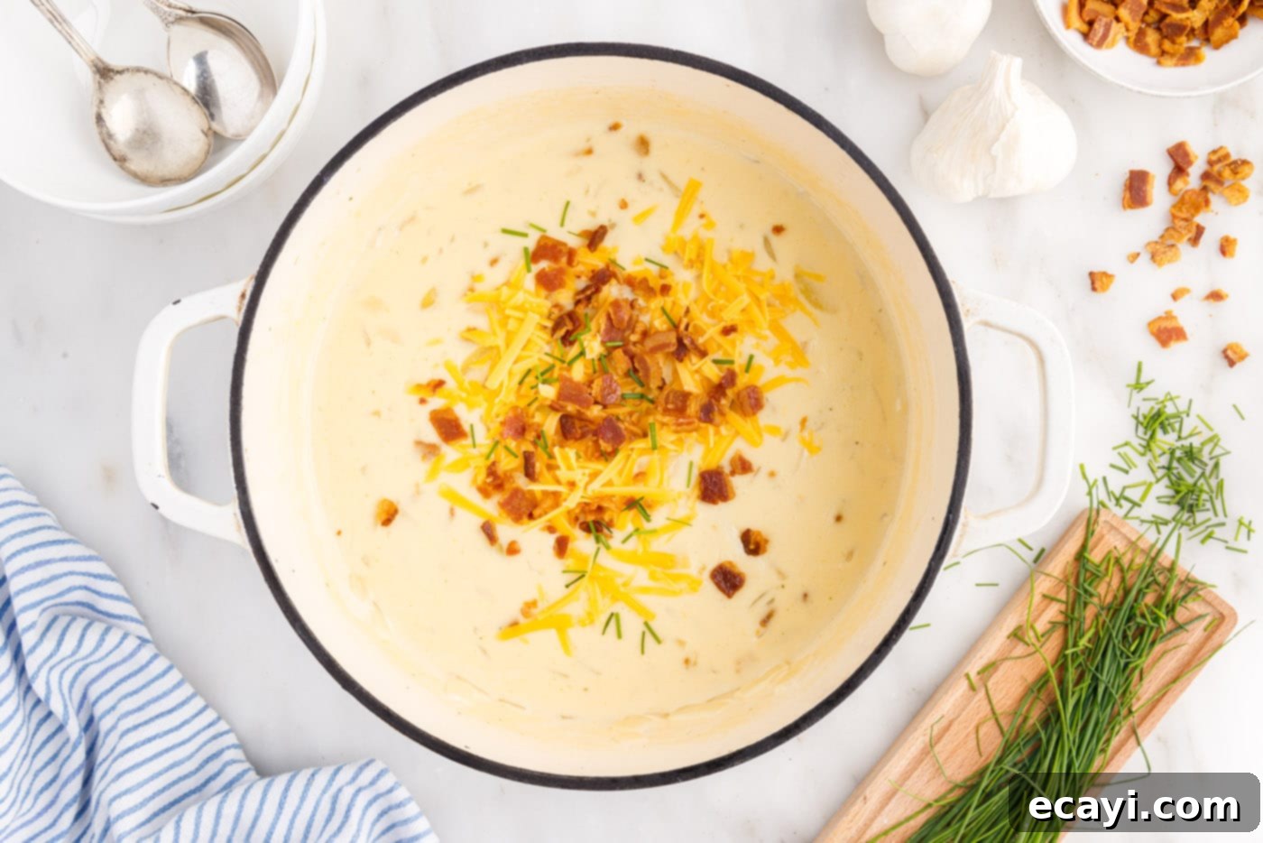 Loaded Baked Potato Soup 14 A large pot filled with delicious, loaded baked potato soup, generously topped with crispy bacon, melted cheese, and fresh chives, ready to be served