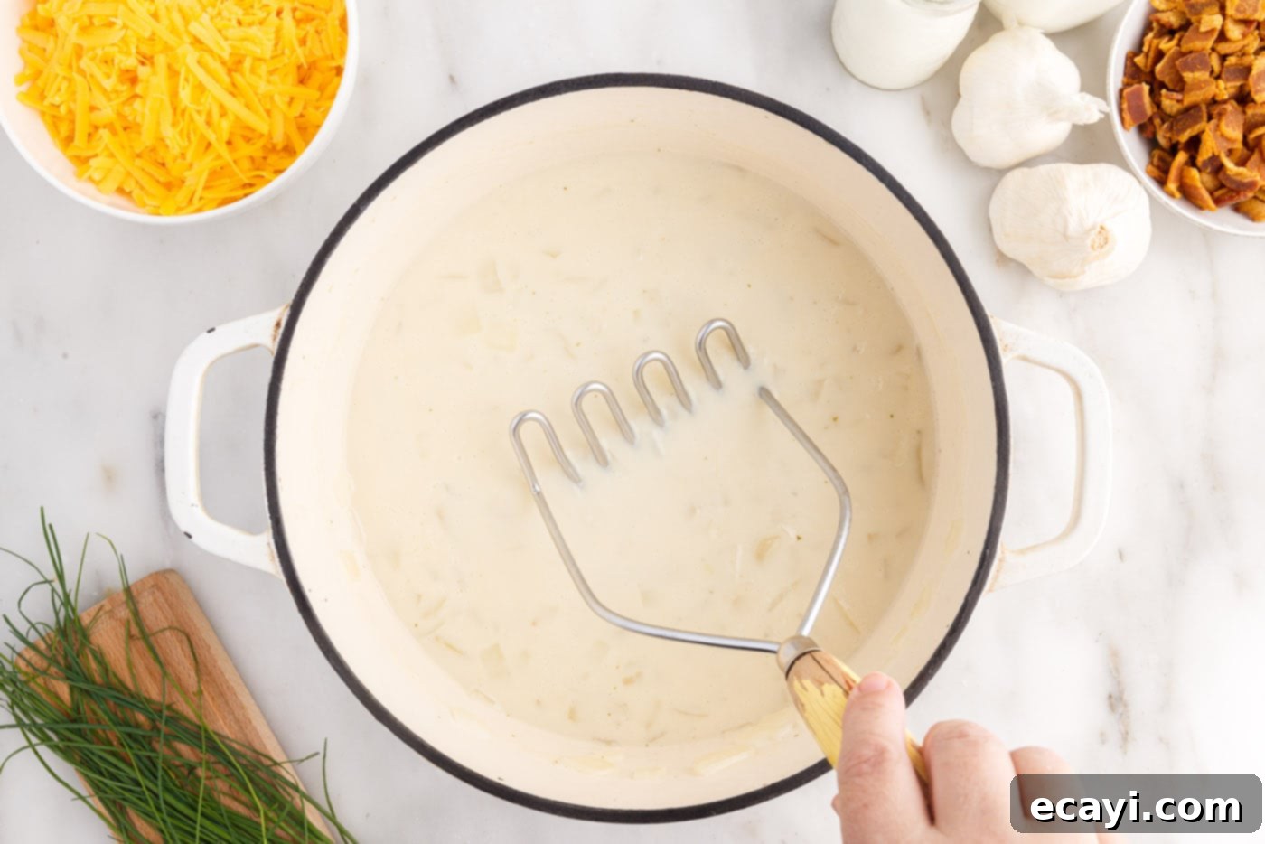 Loaded Baked Potato Soup 10 Mashing potato chunks in the soup with a potato masher to achieve desired consistency, from chunky to creamy