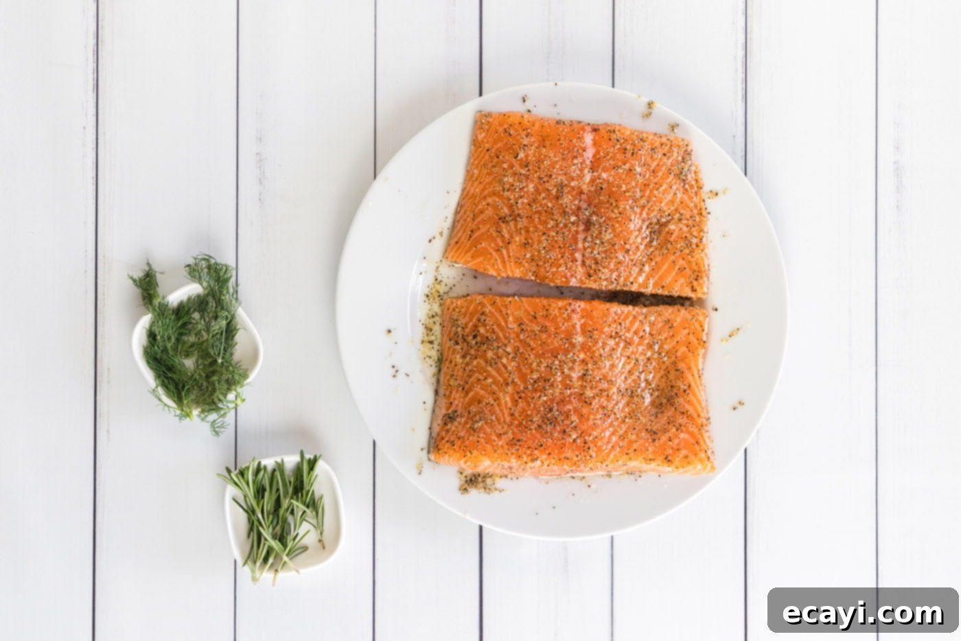 Perfect Sous Vide Salmon 6 A salmon fillet being generously rubbed with the olive oil and seasoning mixture by a gloved hand, ensuring full coverage.