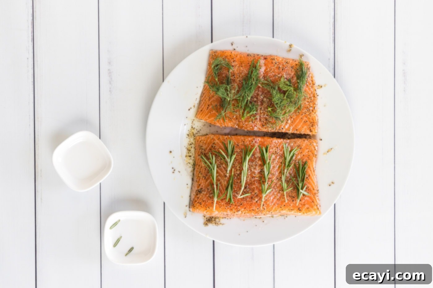 Perfect Sous Vide Salmon 7 Fresh sprigs of rosemary and dill carefully placed on top of the seasoned salmon fillets, ready for vacuum sealing.