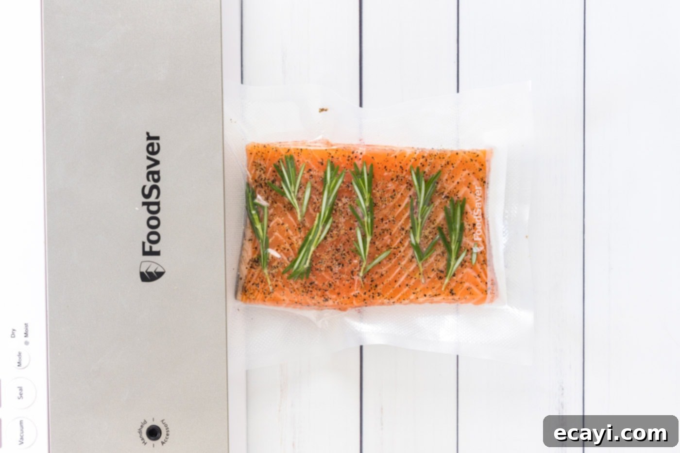 Perfect Sous Vide Salmon 8 Two vacuum-sealed bags, each containing a seasoned salmon fillet with fresh herbs, ready for the sous vide water bath.