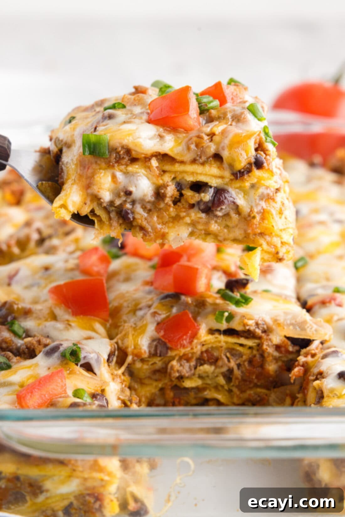 Tex-Mex Lasagna 3 A delicious piece of Mexican Lasagna on a spatula being lifted from the pan
