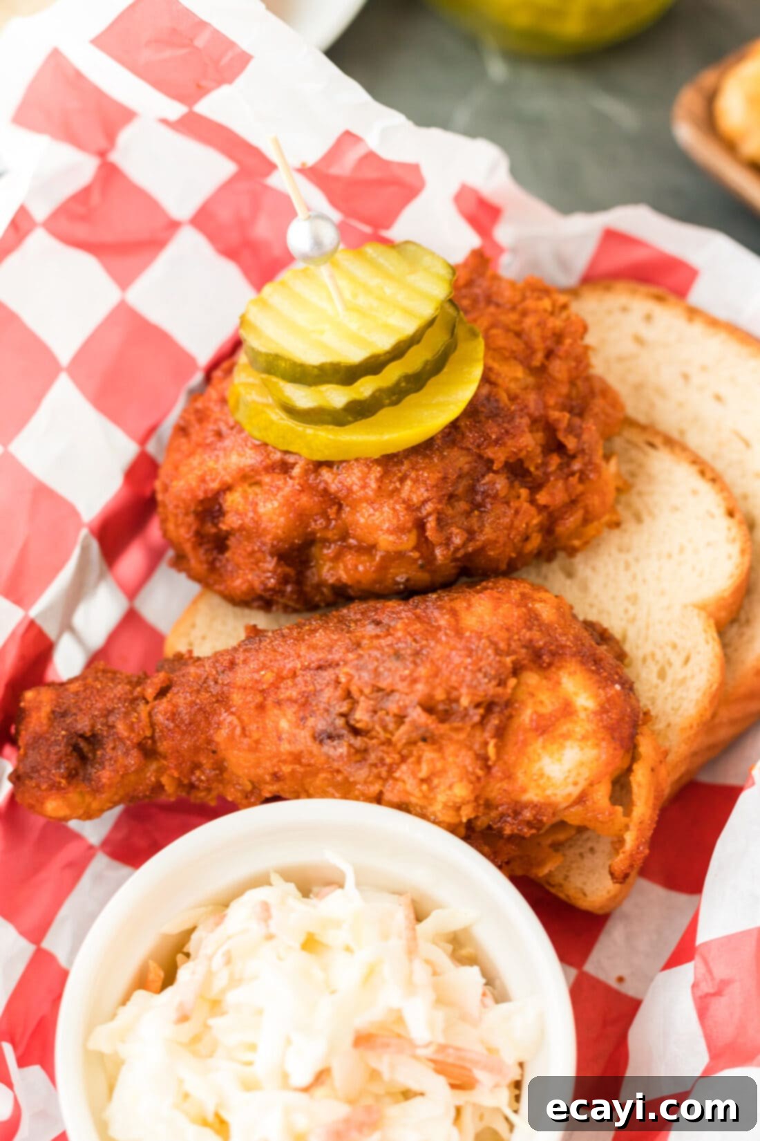Nashville Hot Chicken 3 Basket of crispy Nashville Hot Chicken with a side of creamy coleslaw and pickles.