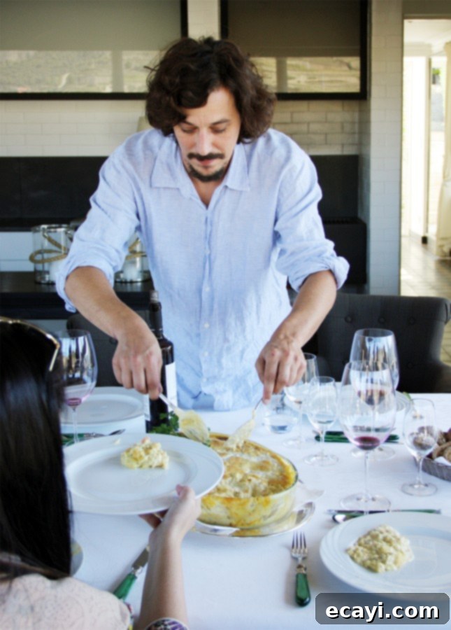 The Northern Portugal Enchantment 14 Quinta do Pesseguiero's winemaker, The winemaker, João Nicolau Almeida, serving a bacalhau casserole for lunch, Douro Valley, Portugal // FoodNouveau.com
