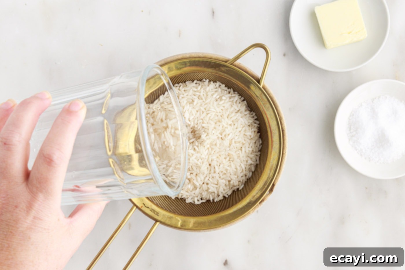 Perfect Fluffy Rice Every Time 5 pouring water over white rice in a sieve to rinse