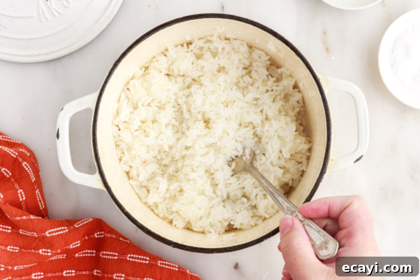 Perfect Fluffy Rice Every Time 10 fluffing white rice with a fork in a saucepan