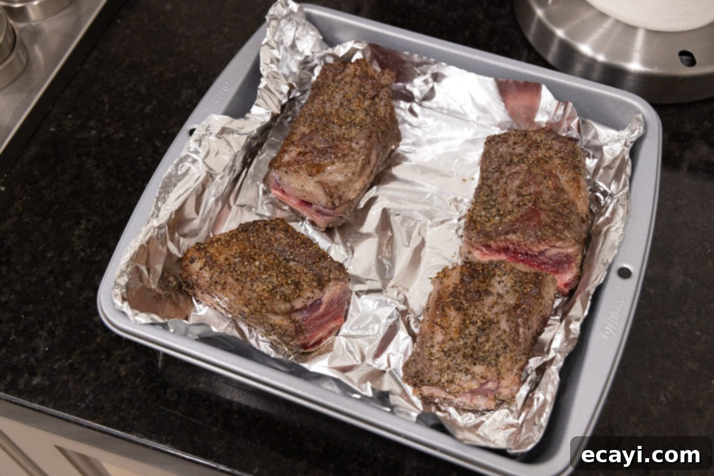 Slow-Cooked Beef Short Ribs 9 Short ribs placed in a baking dish lined with foil