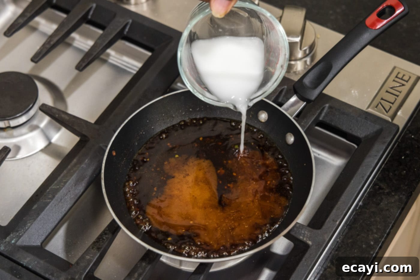 Velvet Salmon Glaze 7 pouring cornstarch slurry into sauce in a skillet