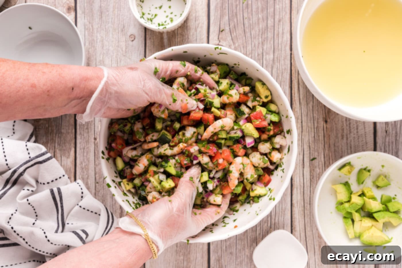 Zesty Lime Shrimp Ceviche 14 hands mixing shrimp ceviche in a bowl