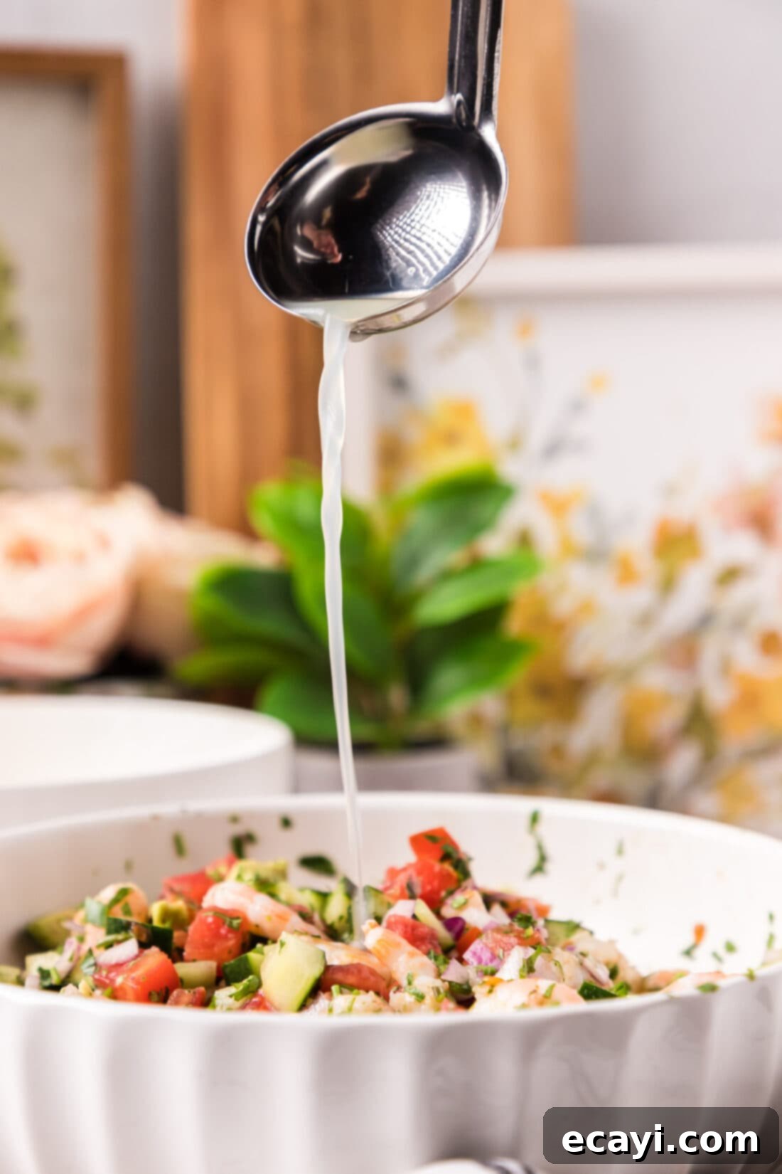 Zesty Lime Shrimp Ceviche 15 Ladle of fruit juices being poured into a bowl of Shrimp Ceviche