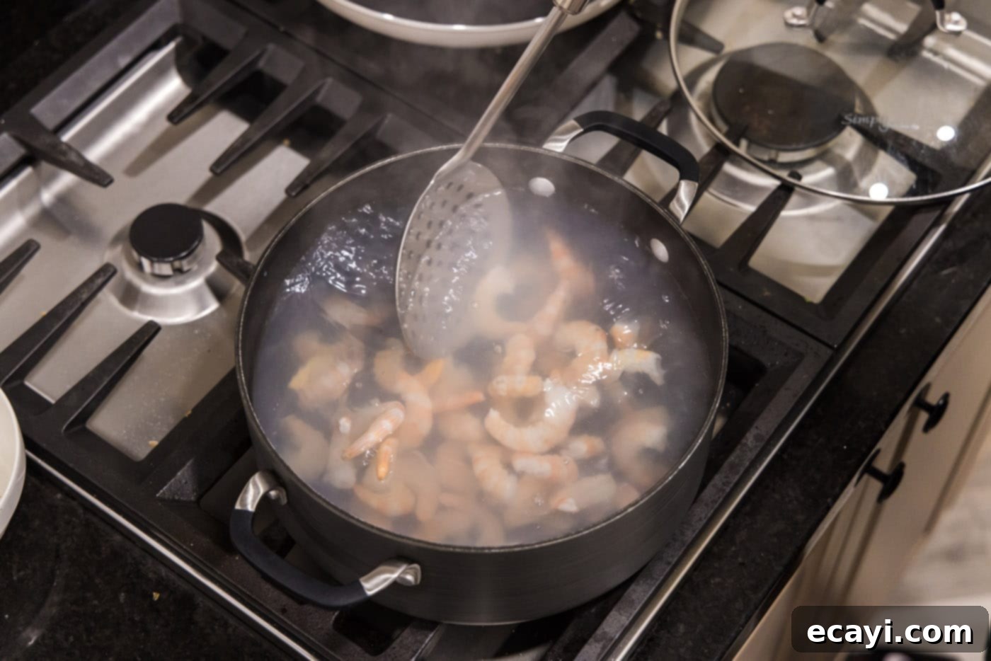 Zesty Lime Shrimp Ceviche 7 removing shrimp from hot water with a slotted spoon