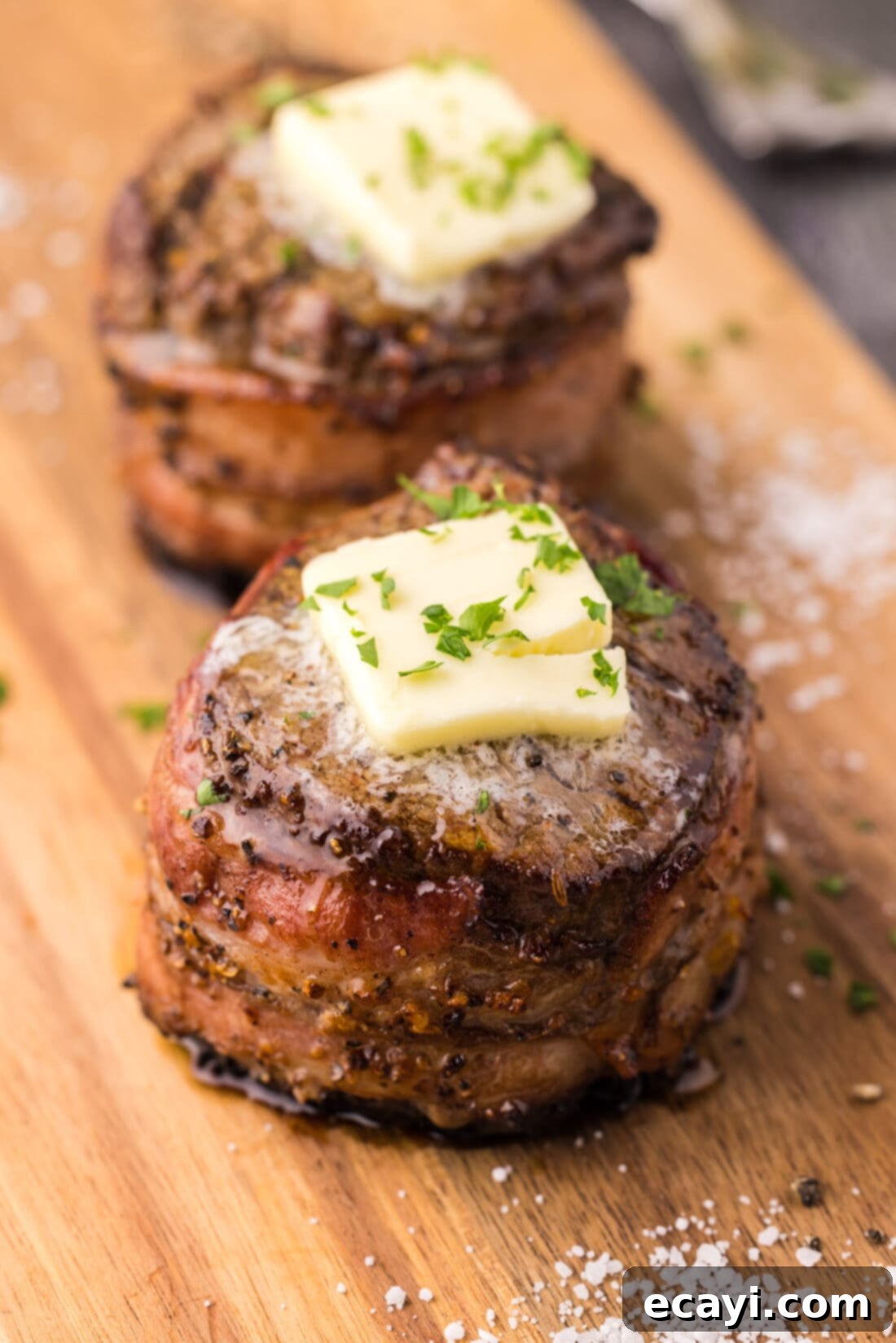 Decadent Bacon-Wrapped Filet 3 Two beautifully cooked Bacon Wrapped Filet Mignon on a elegant platter, ready to be served.