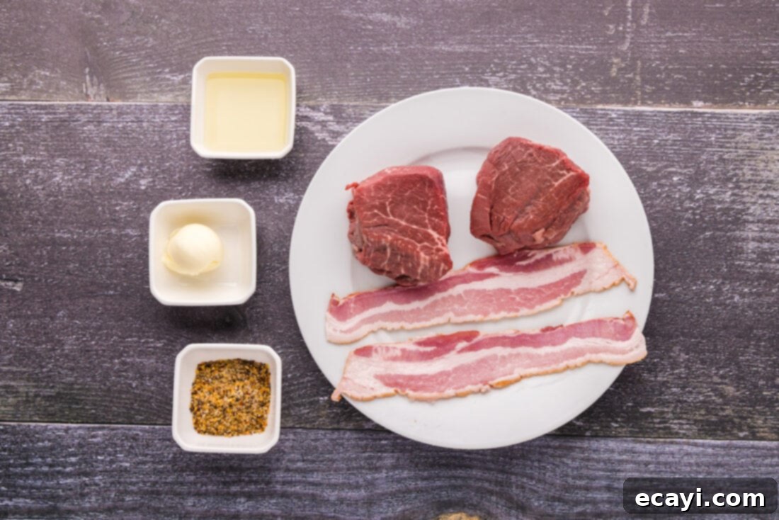 Decadent Bacon-Wrapped Filet 4 A flat lay of fresh ingredients for Bacon Wrapped Filet Mignon, including raw filets, bacon, butter, olive oil, and seasoning.