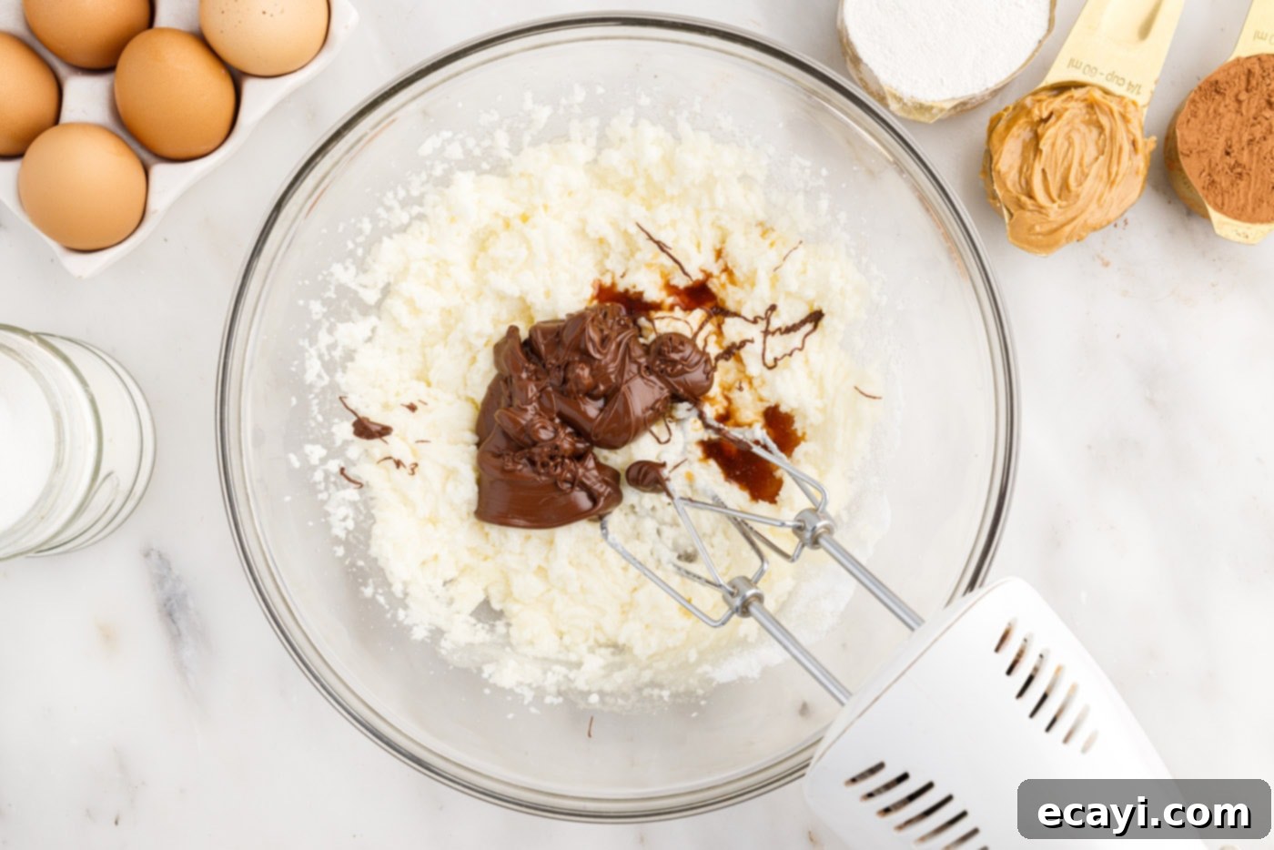 Peanut Butter Brownie Bliss 6 mixer combining melted chocolate and vanilla extract with butter and sugar mixture