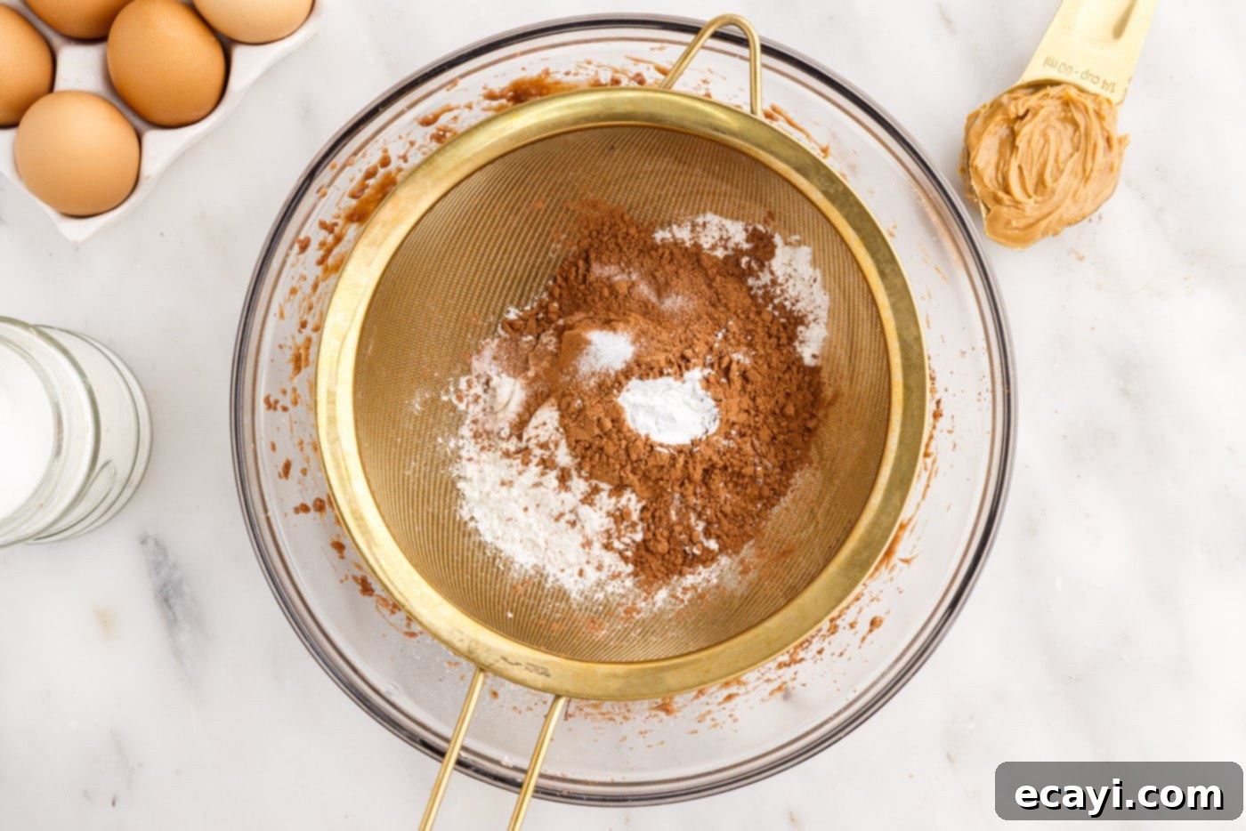 Peanut Butter Brownie Bliss 8 sifting brownie dry ingredients in a bowl